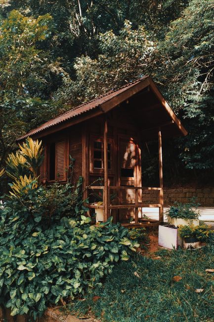 A rustic wooden cabin surrounded by lush greenery in the Brazilian countryside, ideal for a peaceful retreat.