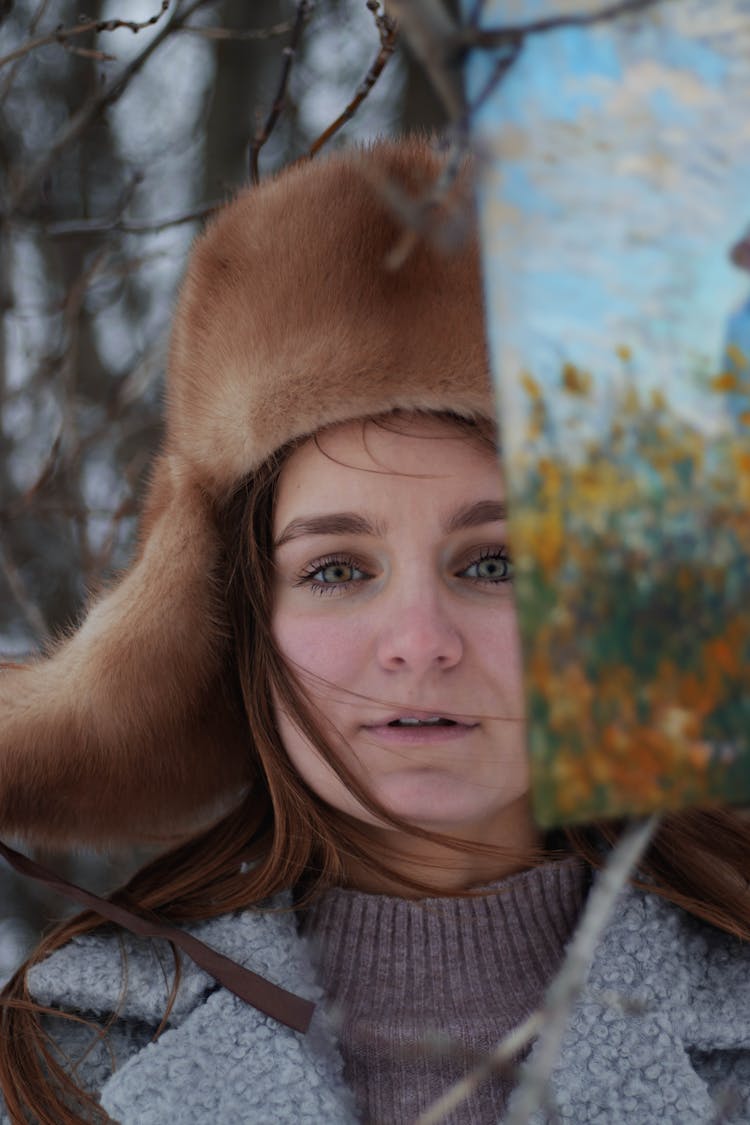 Portrait Of Woman In Fur Hat Holding Up Painting