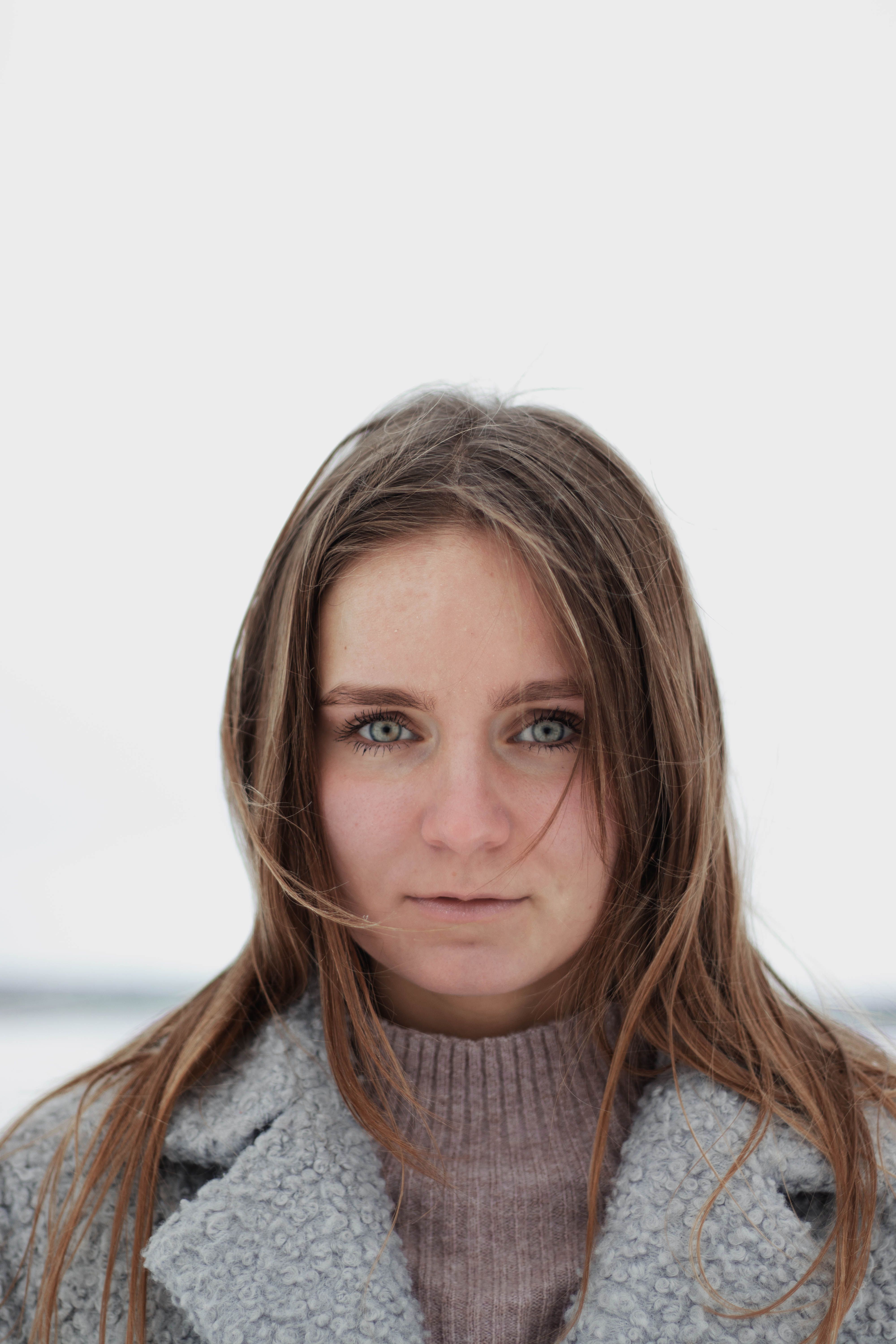 Close-up portrait of a woman in winter clothing outdoors, showcasing natural beauty.