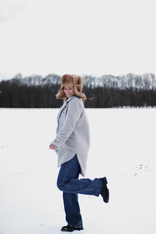 Free Woman Wearing a Coat Standing on Snow Covered Ground Stock Photo