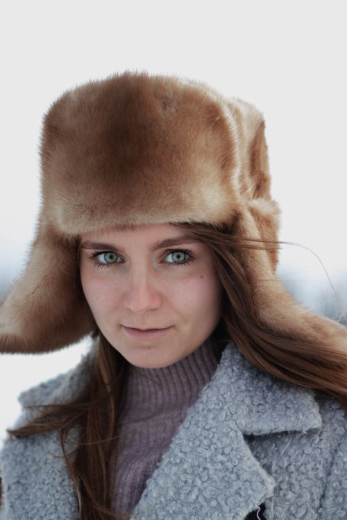 Free Portrait of a woman with blue eyes wearing a fur ushanka in winter. Stock Photo