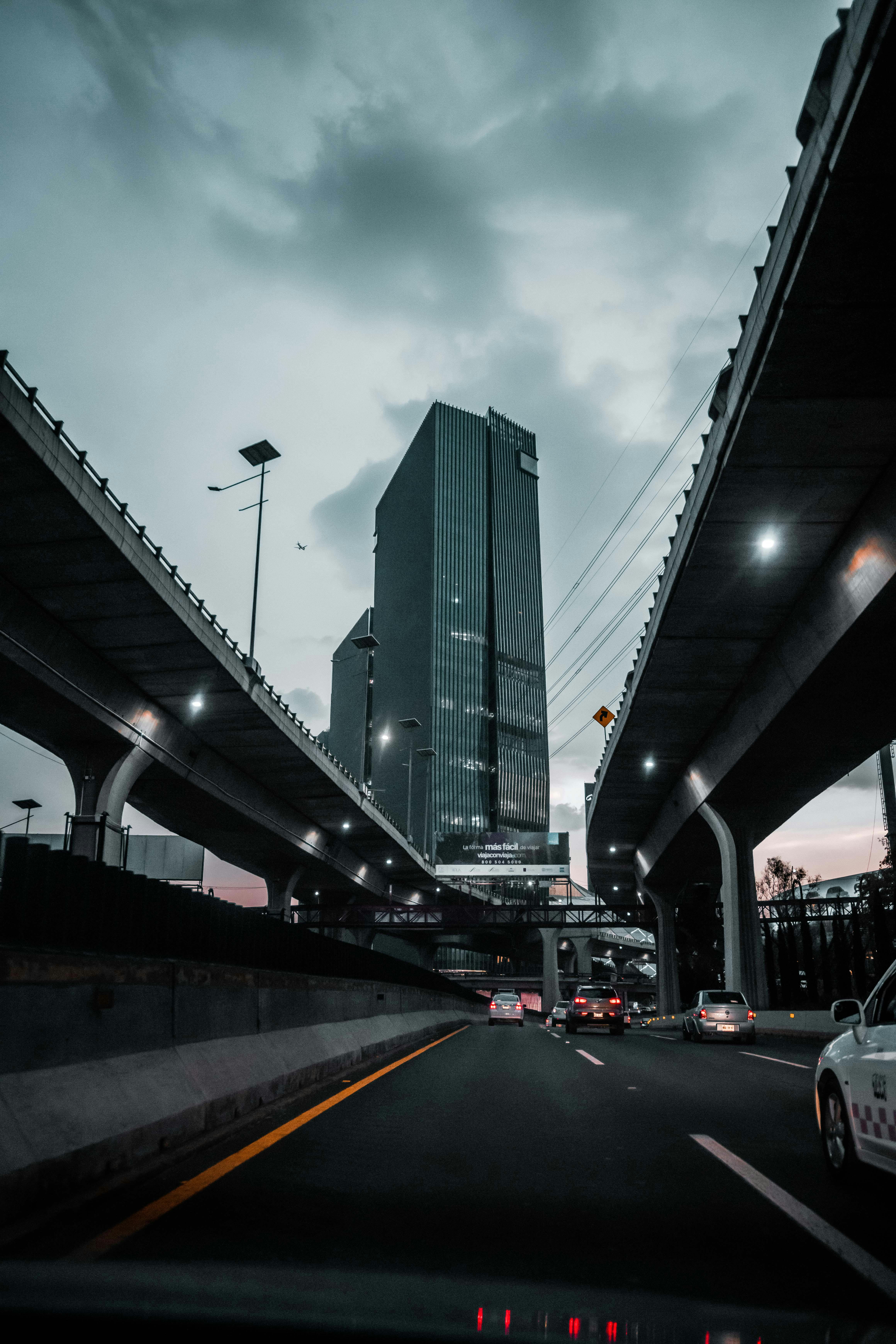 cars on road under a bridge