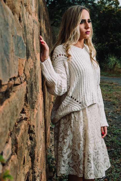 Woman in Knitted V-neck Long-sleeved Shirt and Midi Skirt Standing Beside Wall