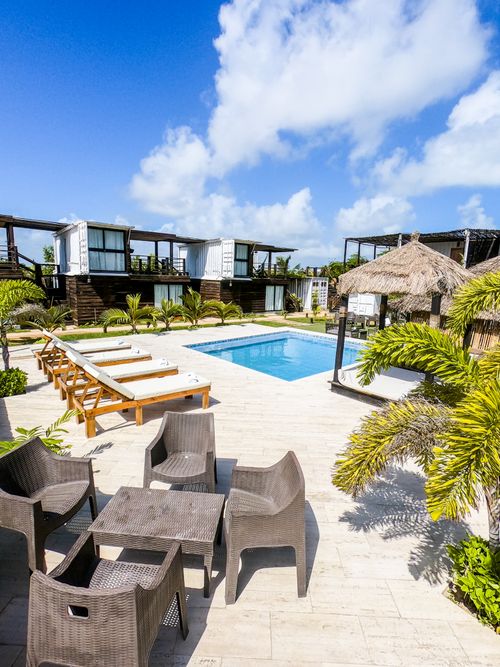 Free Luxurious resort pool area with lounge chairs amidst tropical palm trees. Stock Photo