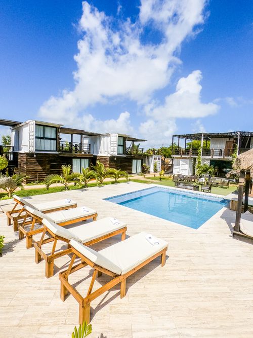 Free Relaxing poolside view at a luxury resort featuring lounge chairs and blue sky. Stock Photo