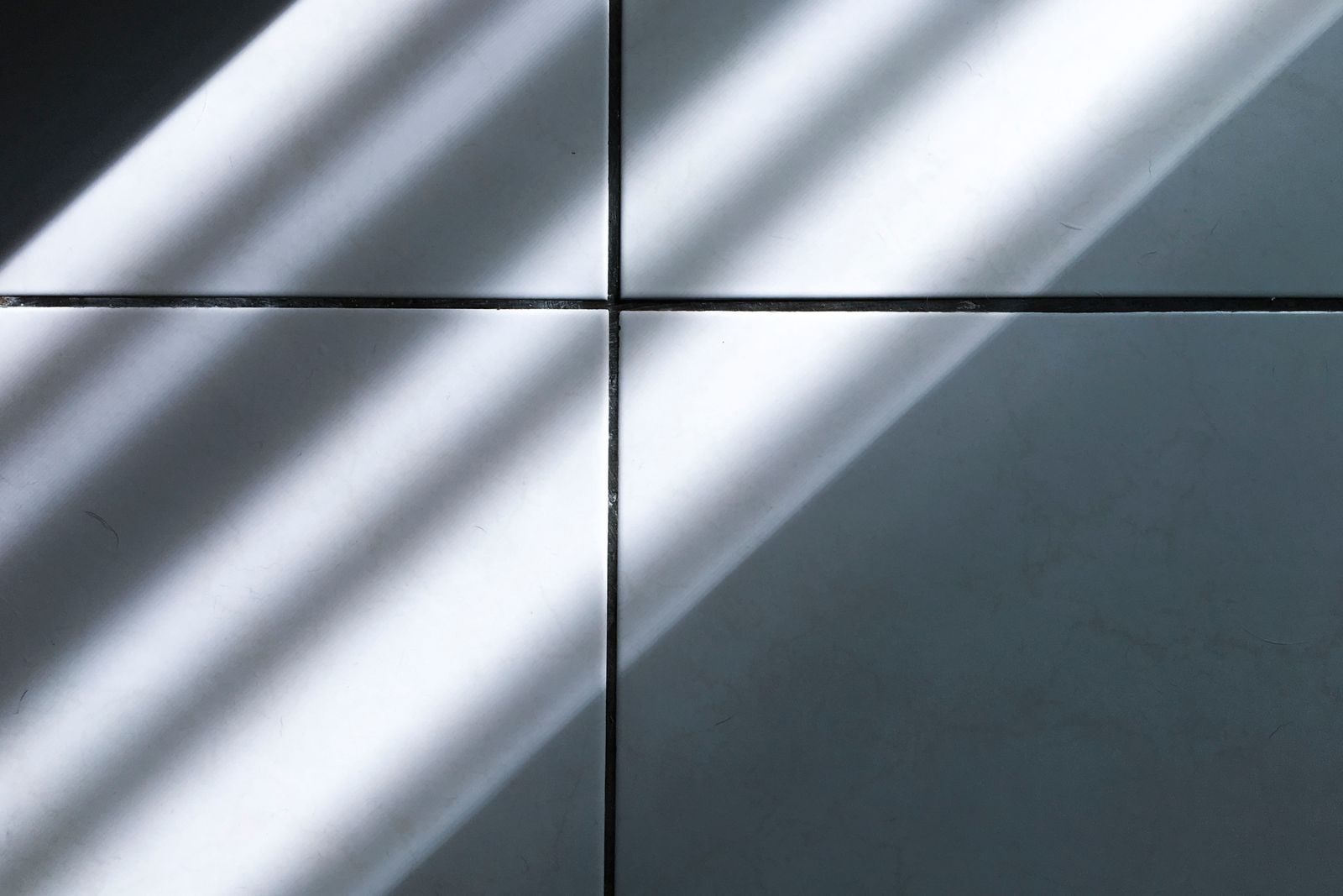 Close-up of white ceramic floor tile with visible grout lines