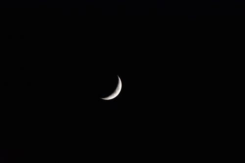 Free A peaceful crescent moon against a dark night sky, captured in monochrome. Stock Photo