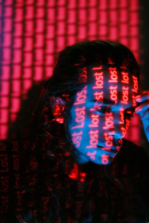 Free Artistic projection of 'lost' text on a person's face, creating a moody visual. Stock Photo