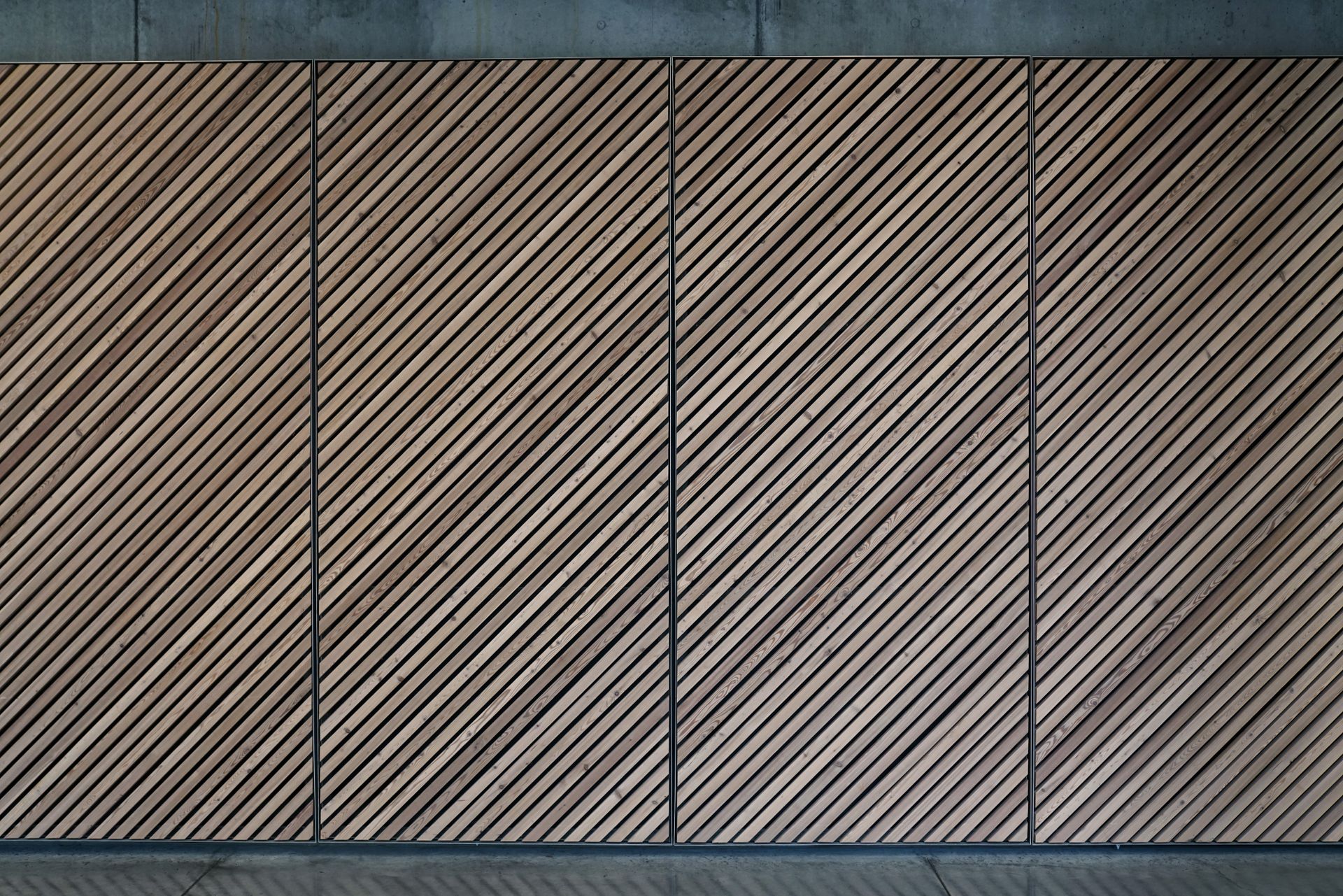 Abstract view of a diagonal wooden panel wall with a textured, patterned design.