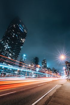 Vibrant Vancouver cityscape at night showcasing dynamic light trails and modern skyscrapers.