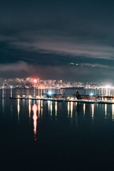 Peaceful night view of Vancouver skyline reflecting on water with seaplanes.