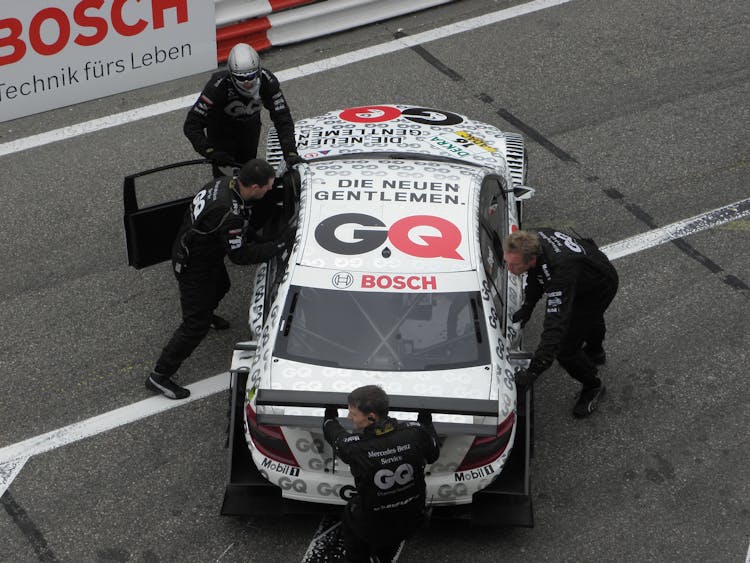 Mechanics Pushing A Race Car