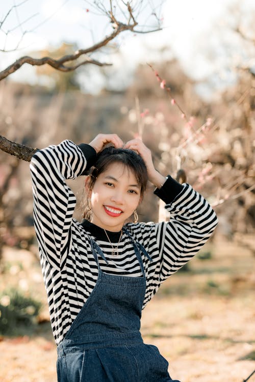 Woman wearing overalls with a striped shirt