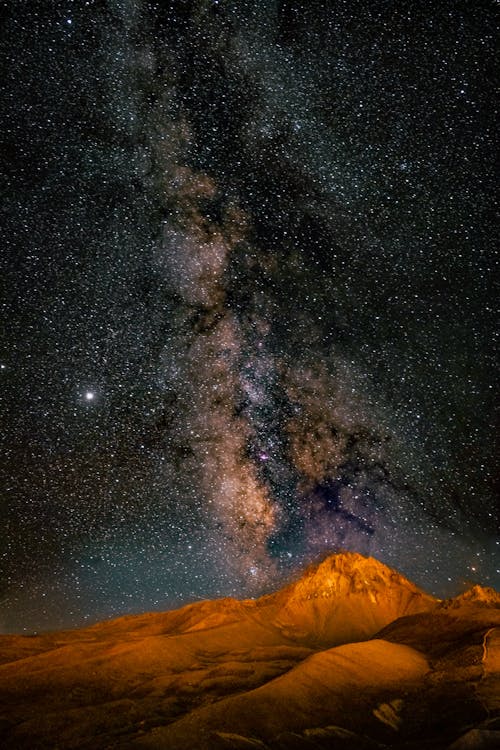 Free Long Exposure Photo of a Desert and Galaxies in Sky Stock Photo