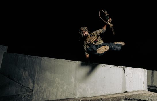 Man Holding a Weapon Jumping over a Surrounding Wall at Night