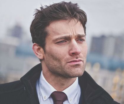 Close-up portrait of a confident businessman outdoors in an urban setting.