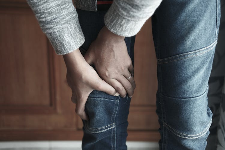 Close-up Of A Person Holding The Knee