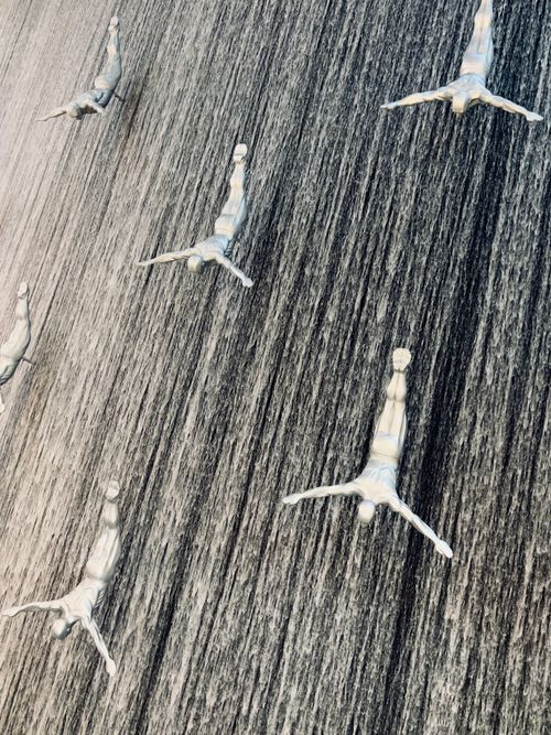 Free Dramatic silver diver sculptures cascade in a mesmerizing vertical display at Dubai Mall. Stock Photo