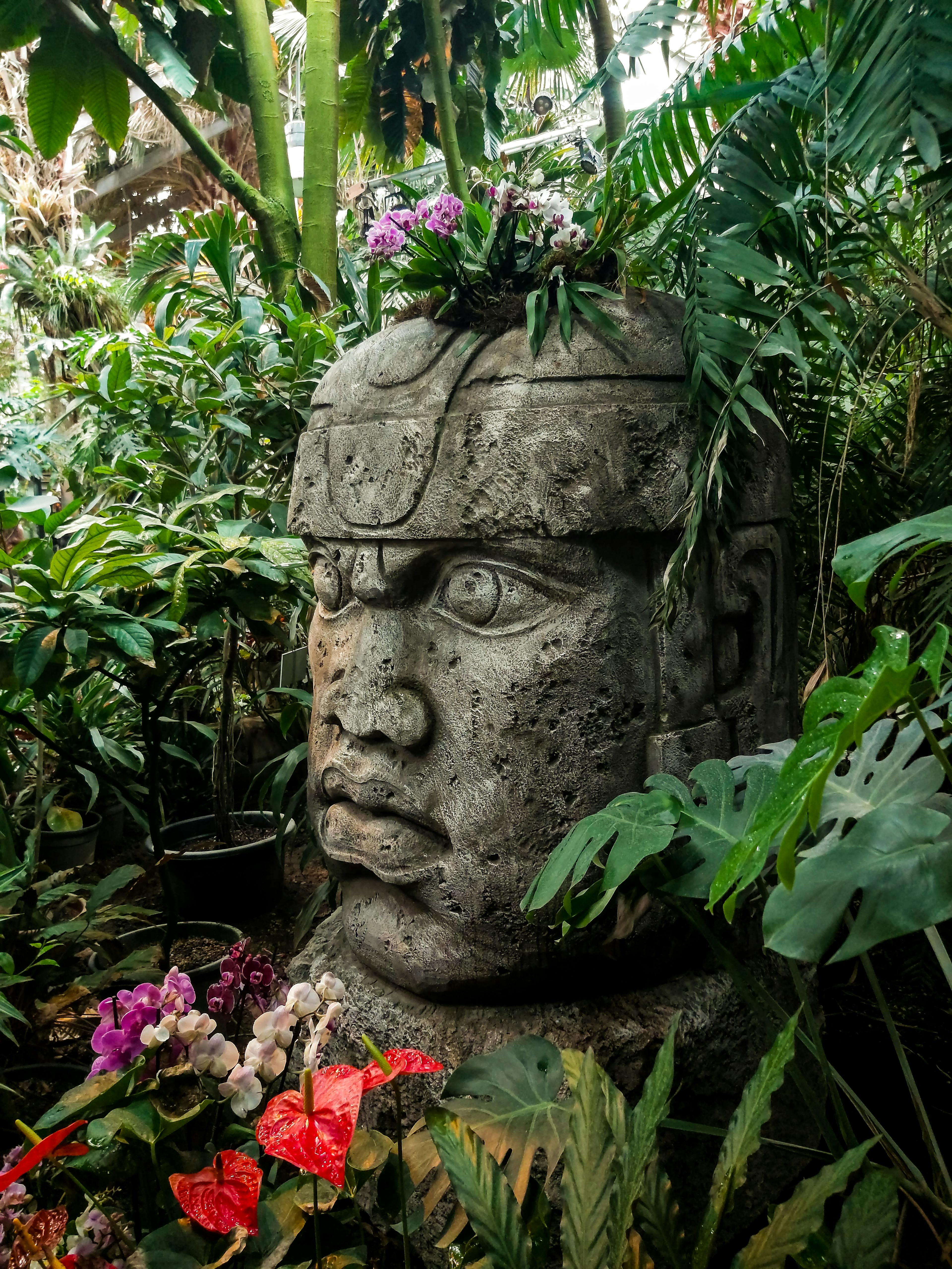 Brown Concrete Statue Near Green Plants
