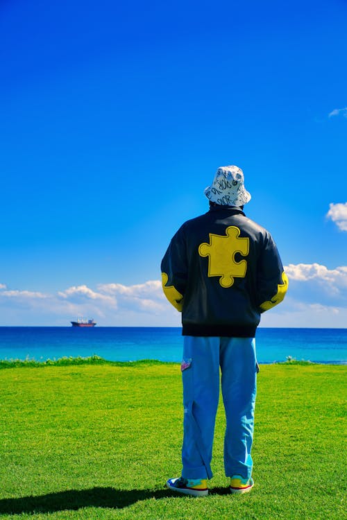 Person Wearing Jacket and a Bucket Hat Standing on Grass