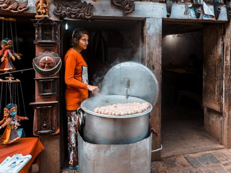 A woman in an orange sweater steaming dumplings at a street market stall.