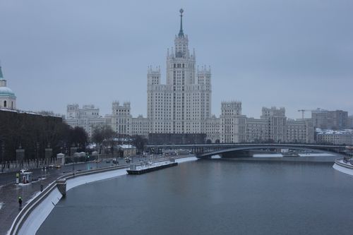 Free Stalinist skyscraper by the river in a winter Moscow cityscape, architectural landmark. Stock Photo