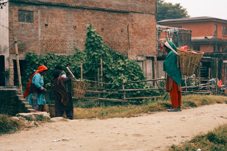 Women Carrying Baskets In A Village 