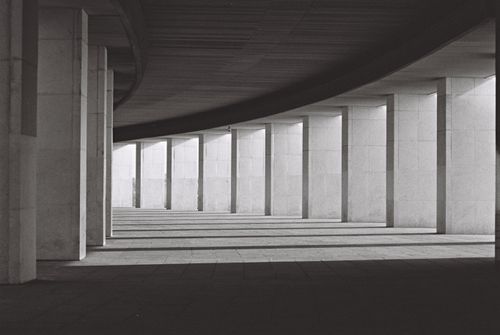 Free Black and white minimalist architectural corridor with concrete pillars and shadows. Stock Photo