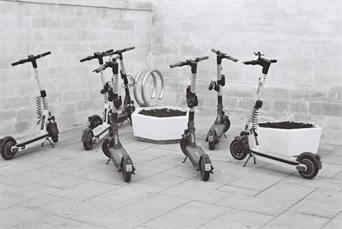Electric Scooters Parked Beside a Wall