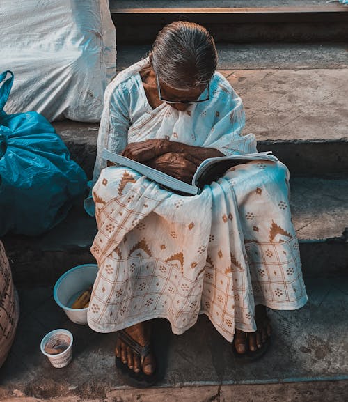 Woman Sitting with Book on Stairs