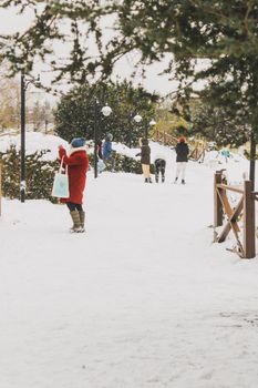 People enjoying a snowy day in a park in İstanbul, Türkiye, with trees and snow-covered paths creating a winter wonderland.
