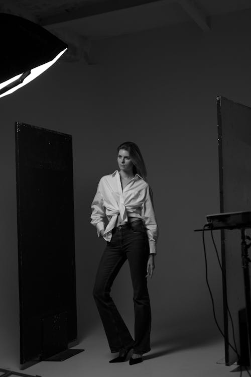 Free Woman in White Dress Shirt and Black Pants Standing on Stage Stock Photo