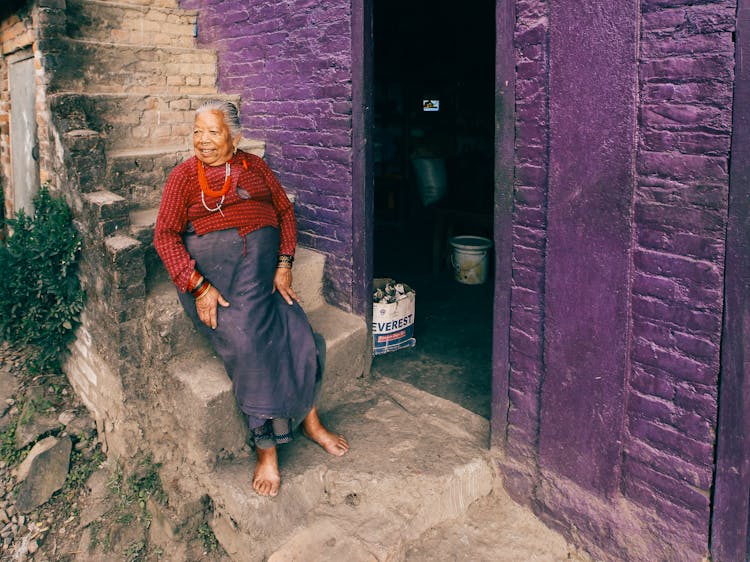 Smiling Elderly Woman Sitting On Stairs