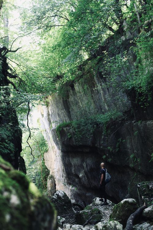 Free A lone adventurer explores a mossy rock formation in lush Ossetian wilderness. Stock Photo