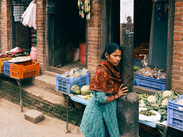 Woman Wearing A Shawl Leaning On A Street Pole