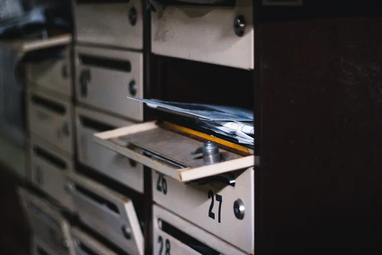 Gros plan sur une main insérant une clé dans le mécanisme d'une serrure de boîte aux lettres