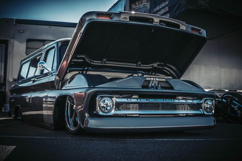 Free Vintage Chevrolet truck with a low suspension and open hood, showcasing its shiny design. Stock Photo