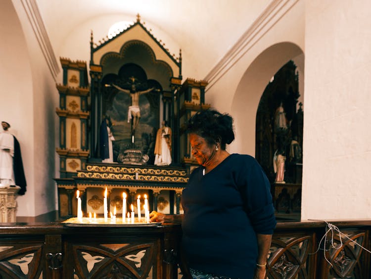 Woman Lightning Candles At Altar