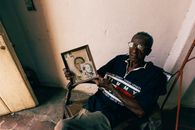 Man Sitting on Chair Holding Pictures