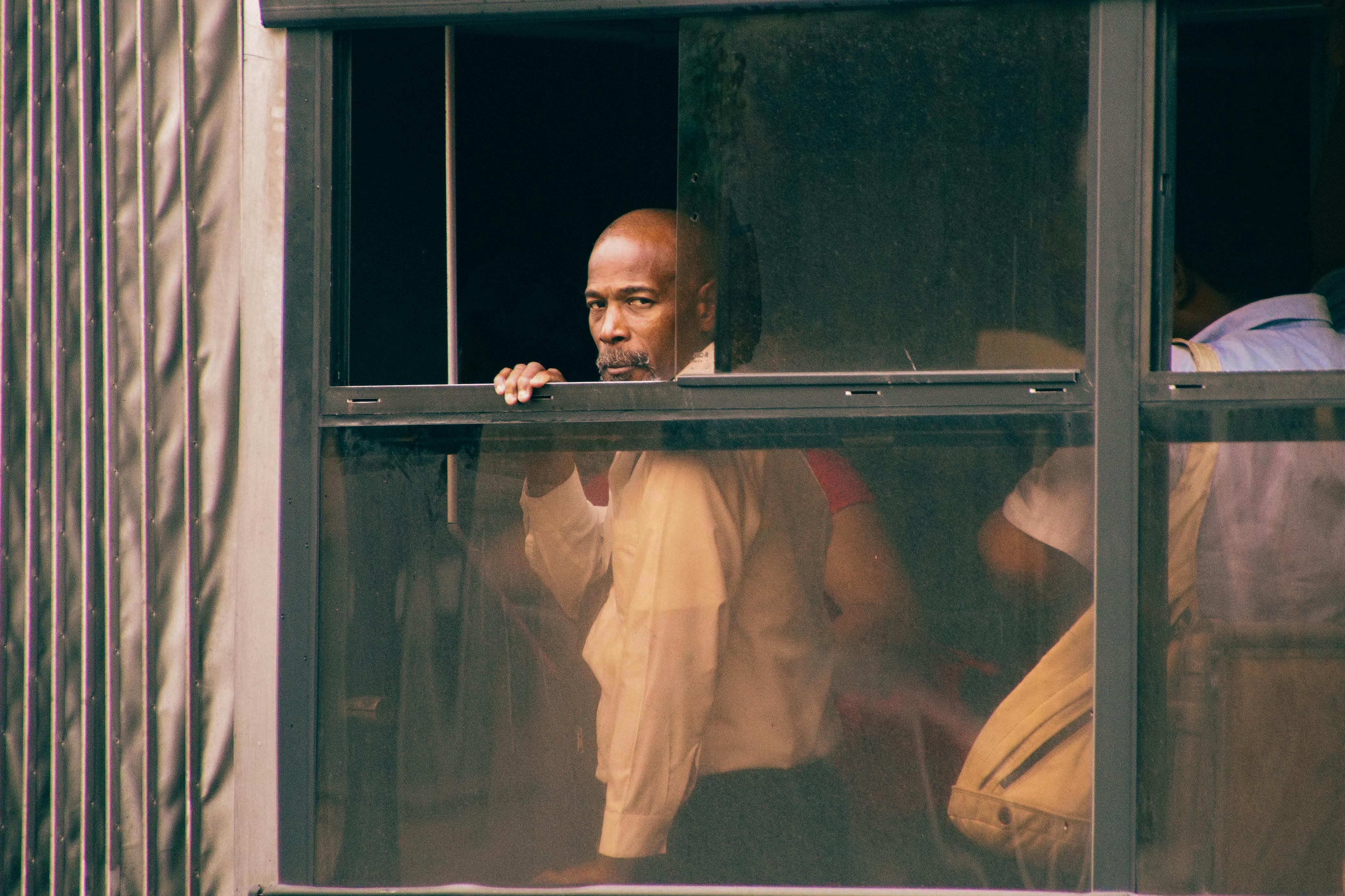 A contemplative man gazes out from a bus window, capturing the essence of urban transit life.