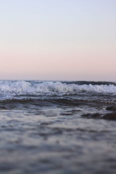 Close-up of gentle ocean waves captured at sunrise, showcasing a tranquil seascape view.