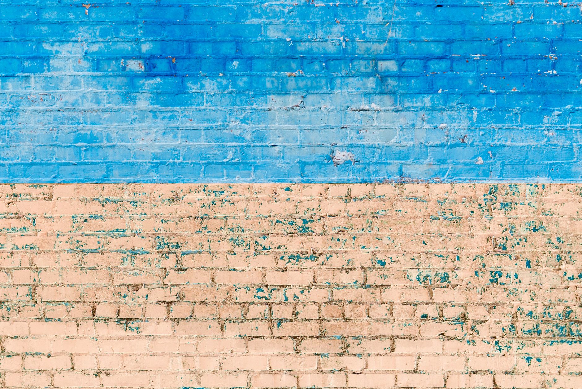 Cost to Paint a Brick House Exterior in Minneapolis in 2026 2 Textured blue and beige painted brick wall with weathered effects, perfect for backgrounds.