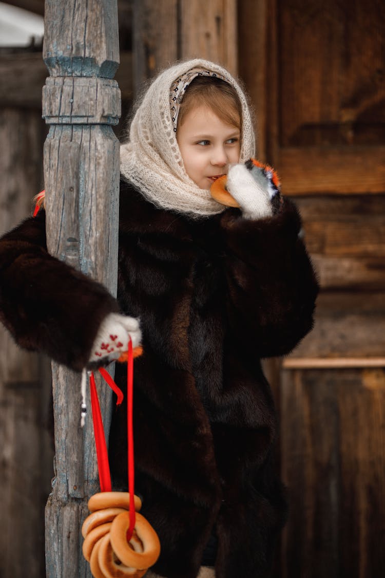 Girl In Fur Coat And Headscarf Eating Bagels