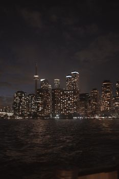 A stunning view of Toronto's illuminated skyline featuring the CN Tower reflected in Lake Ontario.