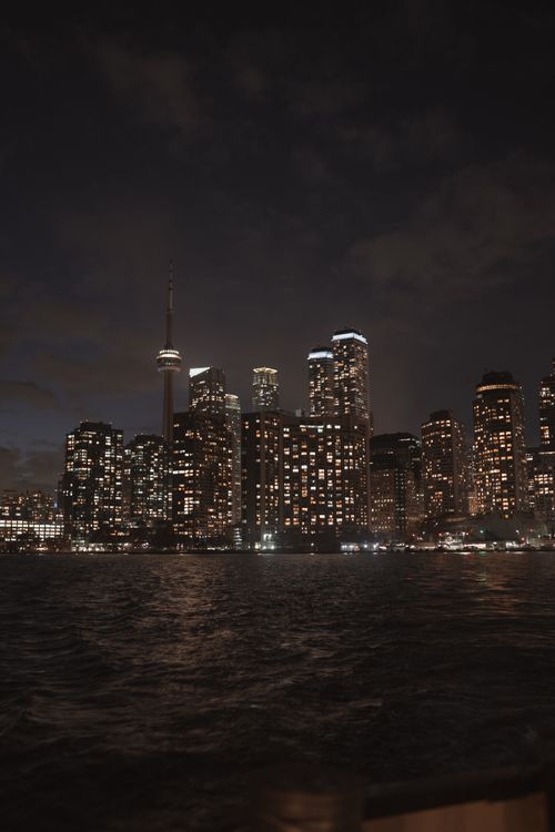 Free A stunning view of Toronto's illuminated skyline featuring the CN Tower reflected in Lake Ontario. Stock Photo