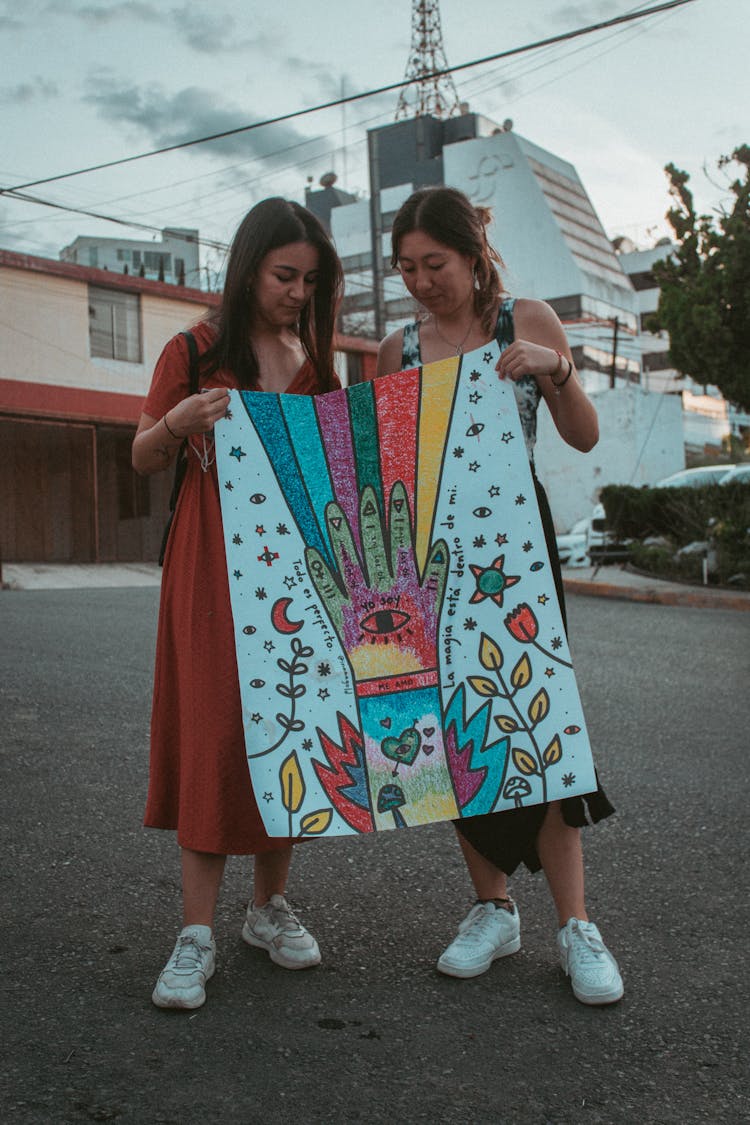 Two Women Holding A Drawing