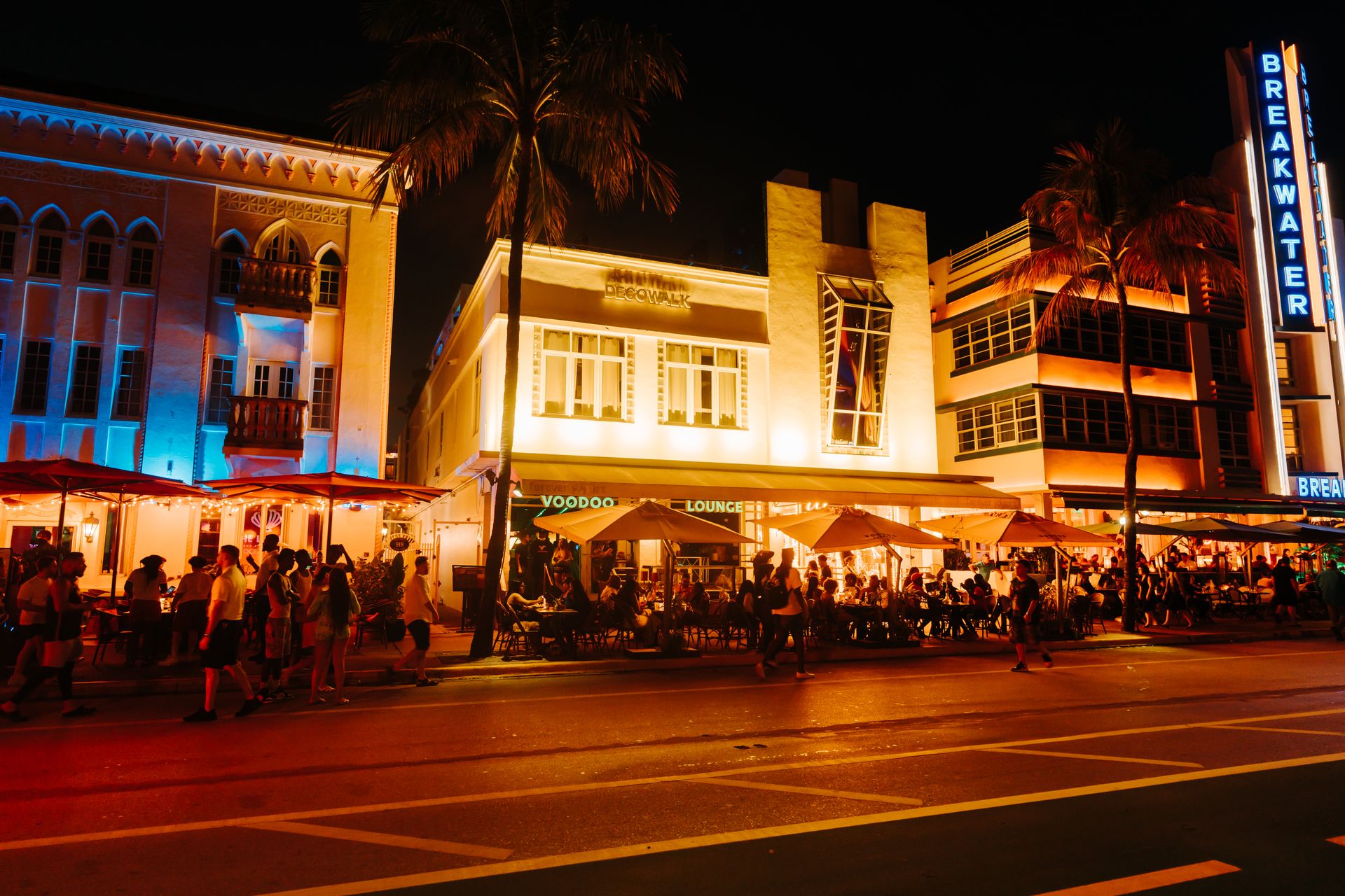 Crowds enjoying Art Deco nightlife on Ocean Drive under illuminated neon lights, Miami Beach.