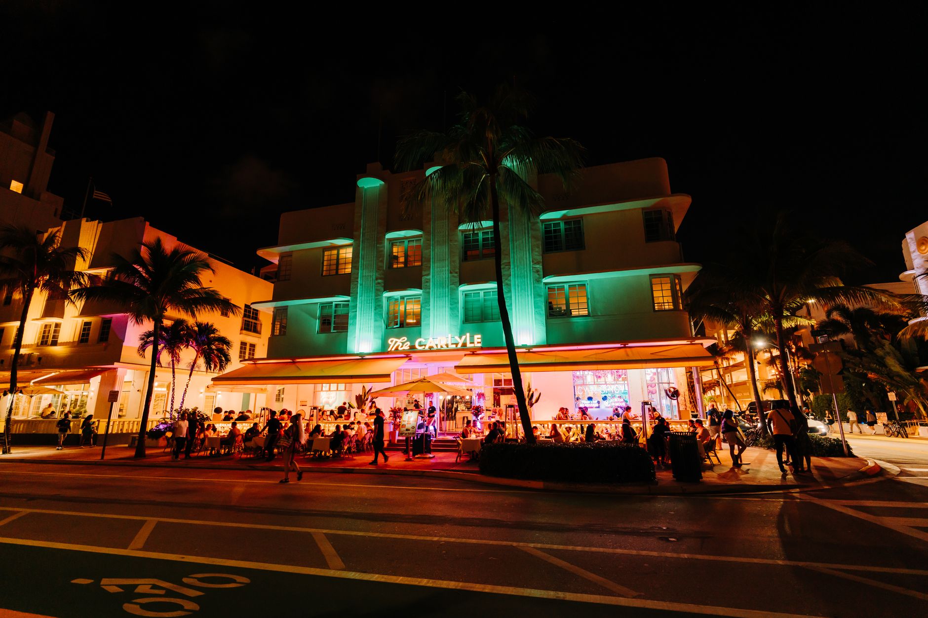 Luxury beachfront condominium towers along Miami Beach with palm trees and ocean views at golden hour