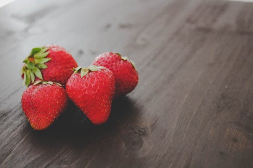 Ripe strawberries heap on wooden table