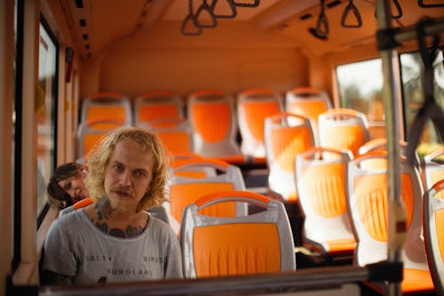 
A Tattooed Man Sitting in a Bus